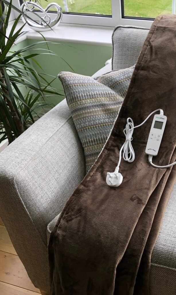 CoziPlus Premium heated throw in brown draped over a sofa